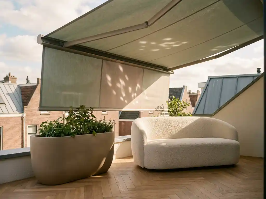 Uitgeschoven terrasoverkapping boven een minimalistisch Dutch dakterras met bouclé loungestoel, keramieke plantenbak en eiken visgraatdeck in saliegroen en taupe tinten.